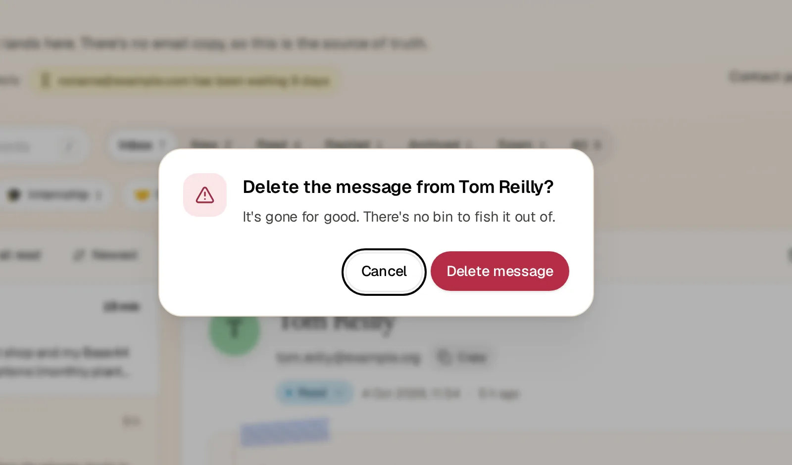 A confirm dialog over the blurred inbox: Delete the message from Tom Reilly? It's gone for good. There's no bin to fish it out of. Cancel has the focus, next to a red Delete message button